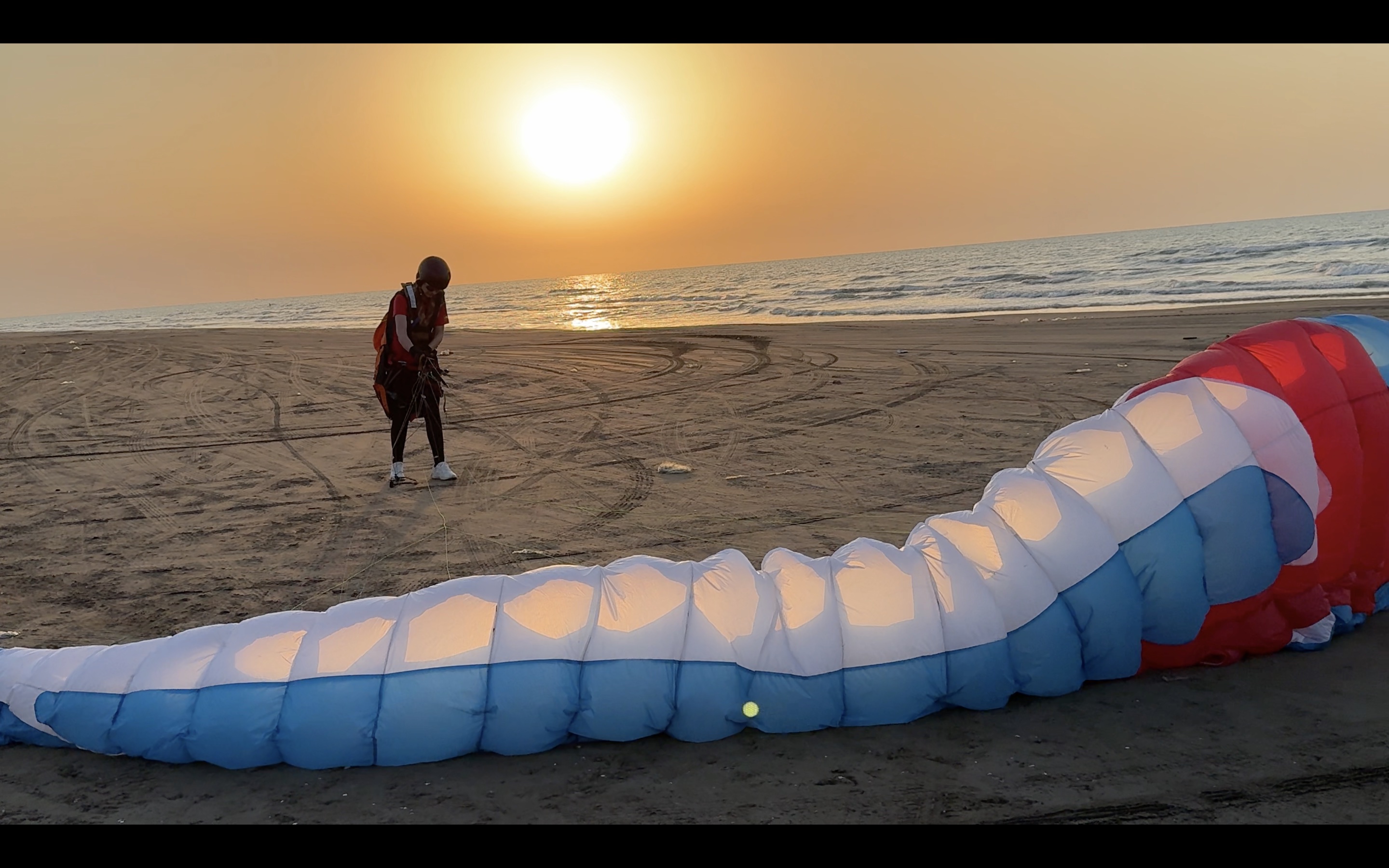 Rising from Aras — a paraglider preparing for flight at sunset